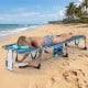 Portable turquoise tanning chair with adjustable backrest, perfect for beach relaxation and sunbathing.
