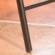 Close-up of a sturdy steel leg of a folding rattan bar chair, designed for comfort and easy storage for outdoor use.
