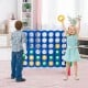 Children enjoying the Jumbo 4-to-Score Giant Game Set, featuring a lightweight design and vibrant rings for engaging.
