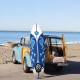6-foot white surf foamie board with blue design, ideal for beginners, placed next to a vintage car on the beach.