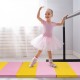 Young girl practicing ballet on a colorful 3-fold gymnastics tumbling fitness mat, ideal for training and exercise.