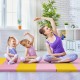 Three children practicing stretches on a pink and yellow 3-fold gymnastics tumbling mat for safe exercise.