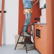 2-step ladder with wide anti-slip pedals, heavy-duty metal frame, ideal for home and office use, shown in a workspace.