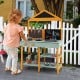 Kids kitchen playset featuring a root viewer planter, rotatable faucet, and chalkboards for creative play in a garden.