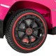Close-up of the black wheel with red accents on the pink 12V Lamborghini kids ride-on sports car for fun outdoor.
