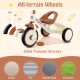 Close-up of all-terrain wheels on a beige toddler tricycle, featuring durable multi-layered construction for stability.