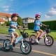 Two kids riding 14-inch bikes with adjustable handlebars and training wheels, perfect for ages 3-5 years old.