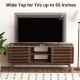 TV stand for TVs up to 65" with sliding doors, adjustable shelves, and walnut finish, perfect for living room storage.