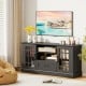 Black TV stand for TVs up to 70 inches featuring glass doors, adjustable shelves, and a drawer for versatile storage.