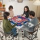 Four players enjoying a game at the 35-inch blue folding mahjong table with cup holders, featuring a smooth felt.