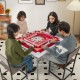 Four players enjoy a game on the 35-inch red folding mahjong table with cup holders, featuring a smooth felt surface.