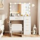 Vanity desk with lighted mirror, ample storage, and padded stool, designed for makeup application and convenience.