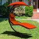 Hanging chaise lounger swing chair in orange with adjustable canopy and soft cushion for outdoor relaxation.