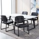 Set of four black leather office reception chairs with cushioned seats and ergonomic backrests for comfort in waiting.