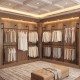 Wall-mounted pipe clothing rack in black with 6 hanging rods, ideal for organizing coats and dresses in walk-in closets.