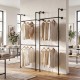 Wall-mounted black pipe clothing rack with two hanging rods, showcasing organized shirts and coats for space-saving.