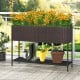 Wicker raised garden bed with storage shelf, featuring drainage gaps, filled with vibrant flowers for outdoor spaces.