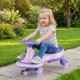 Child joyfully riding the purple Wiggle Car Ride-on Toy with flashing wheels on a garden path, perfect for outdoor play.
