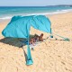 Portable blue beach tent providing 137 sq.ft shade for 6-8 people, ideal for family picnics by the ocean.