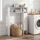 White wood over-the-toilet bathroom space saver featuring shelves and a toilet paper holder for efficient storage.