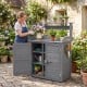 Gray wood plant workstation featuring a stainless steel tabletop, removable shelves, and double door cabinet for gardening tools.