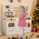 Wooden kids kitchen playset in white with a child playing at the sink, featuring realistic lights and sounds for fun.