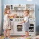 Kids playing with a white wooden play kitchen featuring realistic lights, sounds, and various accessories for.