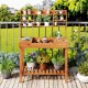 Wooden potting bench table with 3-tier open shelf, ideal for gardening tasks and plant storage on patios or gardens.